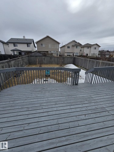 The property features an outdoor wooden deck with railings, overlooking a fenced yard - 3311 21 Street, Edmonton, AB - Outdoor With Exterior