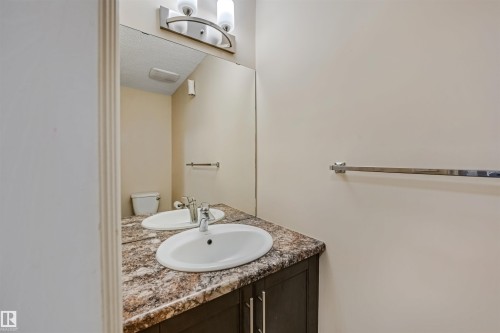 The bathroom features a vanity with a mottled countertop and two oval sinks, each with a chrome faucet - 2314 22 Avenue, Edmonton, AB - Indoor Photo Showing Bathroom