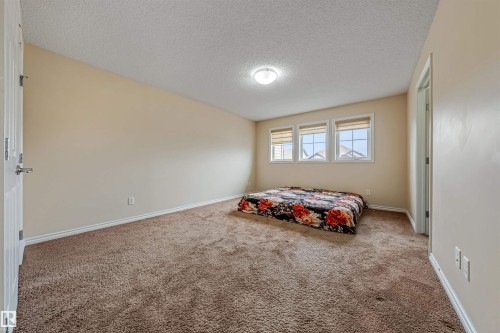 This room features a neutral color palette, three windows with blinds, a ceiling-mounted light fixture, and carpeted floors - 2314 22 Avenue, Edmonton, AB - Indoor Photo Showing Bedroom