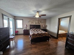 Primary bedroom with ensuite, walk-out sitting deck, and walk-in closet - 