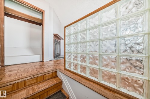 Entryway featuring parquet wood flooring and a glass block wall with a wood frame - 12411 126 Street Nw, Edmonton, AB - Indoor Photo Showing Other Room