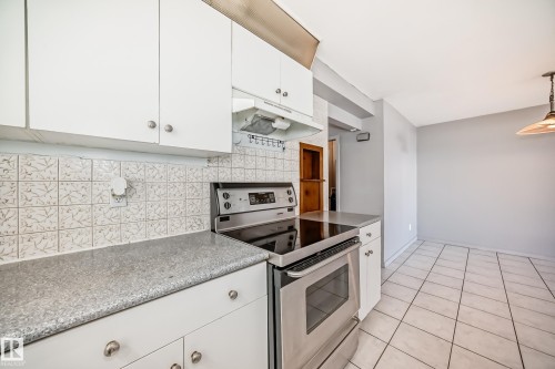 Kitchen featuring white cabinetry, a light-colored countertop, and a stainless steel oven - 12411 126 Street Nw, Edmonton, AB - Indoor Photo Showing Kitchen