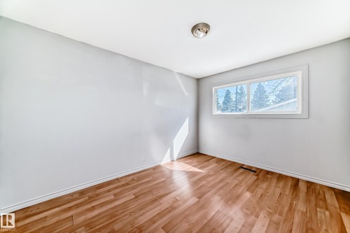 This room features light-colored walls, wood flooring, and a window providing natural light - 12411 126 Street Nw, Edmonton, AB - Indoor Photo Showing Other Room