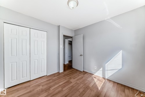 This interior space features light-colored walls and wood-look flooring - 12411 126 Street Nw, Edmonton, AB - Indoor Photo Showing Other Room