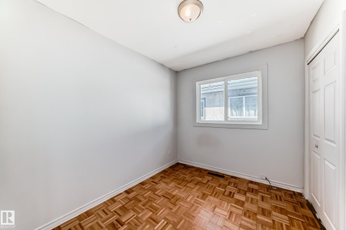 This room features light-colored walls, a window, and a closed bi-fold door - 12411 126 Street Nw, Edmonton, AB - Indoor Photo Showing Other Room