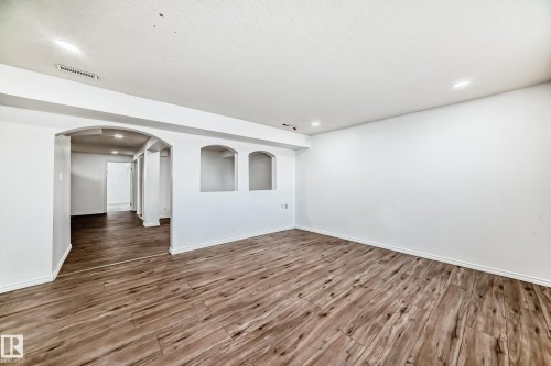 The property features wood-style flooring and bright white walls, complemented by recessed lighting - 12411 126 Street Nw, Edmonton, AB - Indoor Photo Showing Other Room