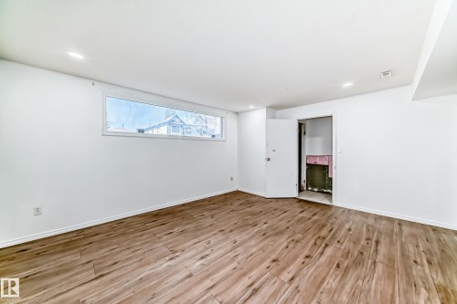 Spacious room featuring light wood-style flooring, white walls, and a rectangular window - 12411 126 Street Nw, Edmonton, AB - Indoor Photo Showing Other Room