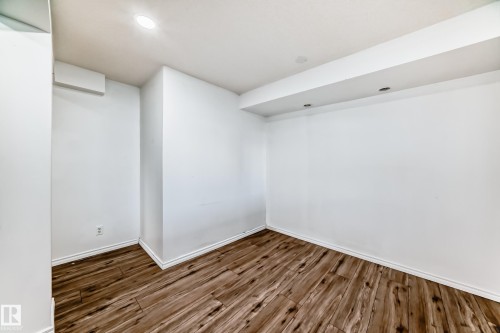 This room features white walls, recessed lighting, and hardwood style flooring - 12411 126 Street Nw, Edmonton, AB - Indoor Photo Showing Other Room