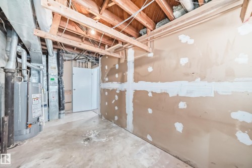 This property features a partially finished lower level with exposed ceiling joists and visible ductwork - 12411 126 Street Nw, Edmonton, AB - Indoor Photo Showing Basement