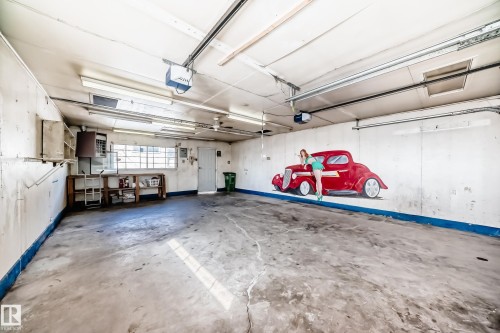 Spacious garage with concrete flooring, fluorescent lighting, and a window providing natural light - 12411 126 Street Nw, Edmonton, AB - Indoor Photo Showing Garage