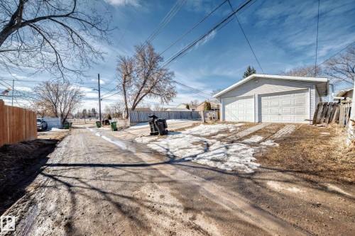 The property features a detached two-car garage with white paneled garage doors - 12411 126 Street Nw, Edmonton, AB - Outdoor