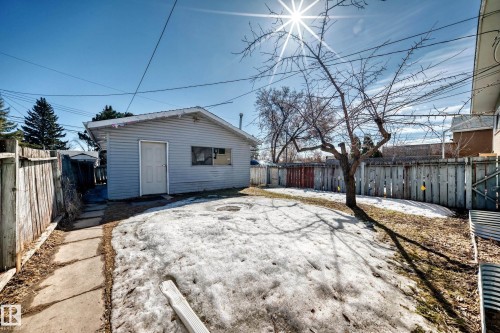 The property features a detached garage with siding and a side door, a fenced yard, and a tree - 12411 126 Street Nw, Edmonton, AB - Outdoor