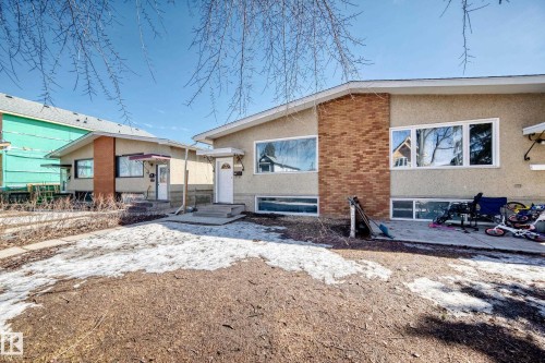 The property features a stucco exterior with brick accents and multiple windows - 12411 126 Street Nw, Edmonton, AB - Outdoor