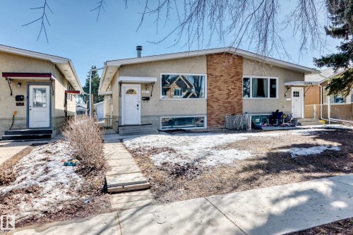 The property features a stucco exterior with brick accents, white windows, and multiple entryways - 12411 126 Street Nw, Edmonton, AB - Outdoor