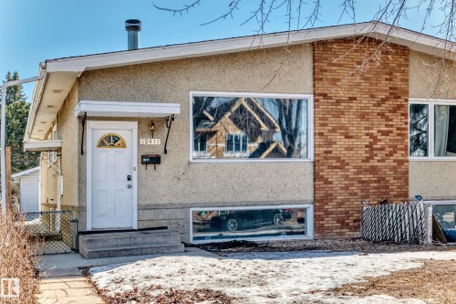 The property features a stucco exterior with brick accents and a white front door with an arched window - 12411 126 Street Nw, Edmonton, AB - Outdoor