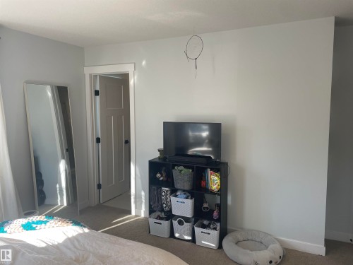 The room features light-colored walls and carpeting, with a white door frame and door - 15220 105 Avenue, Edmonton, AB - Indoor Photo Showing Bedroom