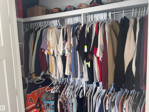 Well-designed closet space featuring dual hanging rods and an upper storage shelf - 15220 105 Avenue, Edmonton, AB - Indoor With Storage