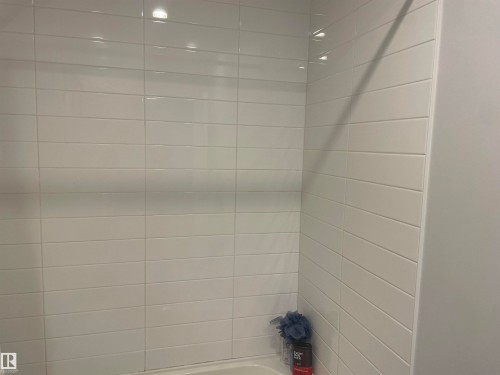 Bathroom featuring white rectangular tile walls and a white tub - 15220 105 Avenue, Edmonton, AB - Indoor Photo Showing Bathroom