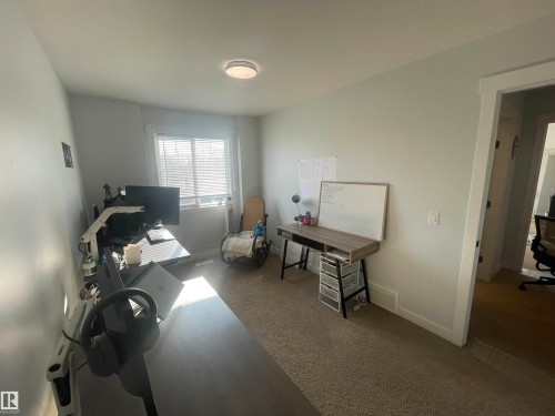 This versatile room features light gray walls, a window with blinds, and carpeted flooring - 15220 105 Avenue, Edmonton, AB - Indoor