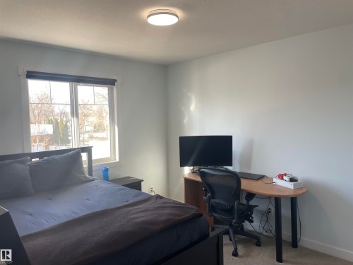This room features a window providing natural light, a ceiling light fixture, and light-colored walls - 15220 105 Avenue, Edmonton, AB - Indoor
