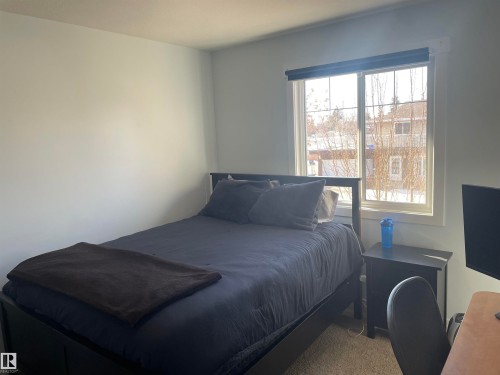 Bedroom featuring a window with a view of trees and a neutral carpet - 15220 105 Avenue, Edmonton, AB - Indoor Photo Showing Bedroom