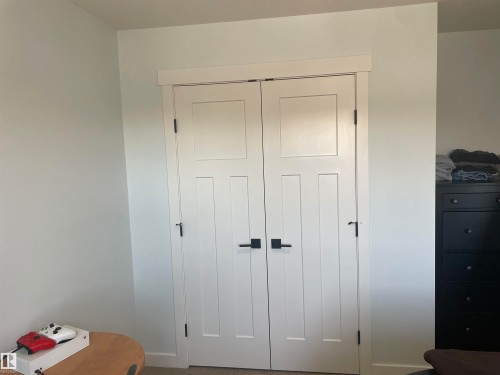 The property features white interior walls and white doors with dark hardware - 15220 105 Avenue, Edmonton, AB - Indoor