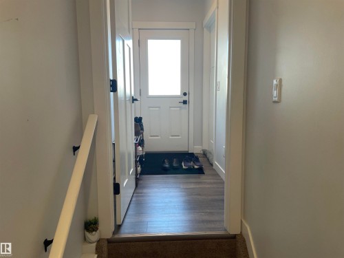 Entryway featuring a white door with a window, dark hardware, and dark wood-style flooring - 15220 105 Avenue, Edmonton, AB - Indoor Photo Showing Other Room