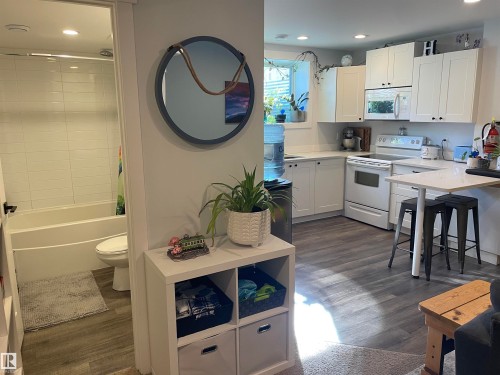 This property features a kitchen with white cabinetry, white countertops, and white appliances - 15220 105 Avenue, Edmonton, AB - Indoor Photo Showing Kitchen