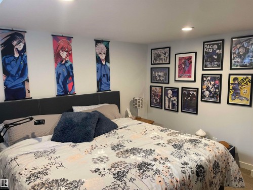 Bedroom featuring recessed lighting, a dark headboard, and a patterned comforter - 15220 105 Avenue, Edmonton, AB - Indoor Photo Showing Bedroom