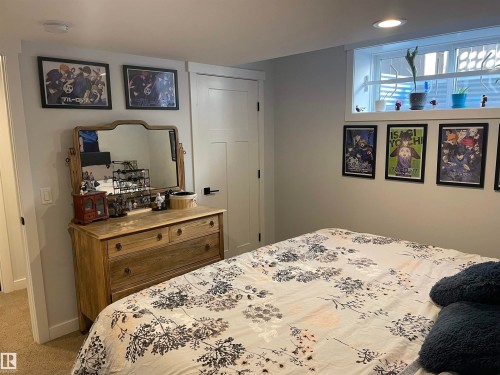 This room features a window with an interior ledge, a light-colored carpet, and a white paneled door - 15220 105 Avenue, Edmonton, AB - Indoor Photo Showing Bedroom