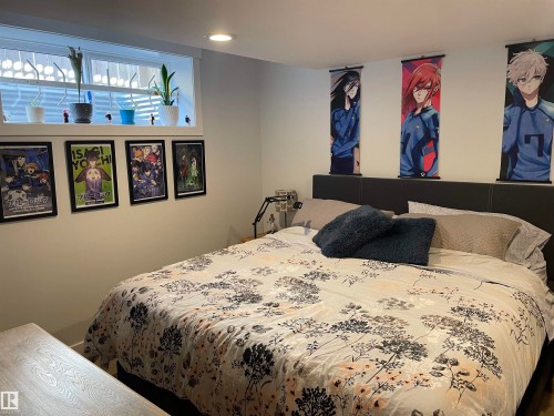 A bedroom featuring a window with a security bar and several potted plants - 15220 105 Avenue, Edmonton, AB - Indoor Photo Showing Bedroom