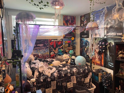 The property includes a room featuring a window with a valance, a ceiling-mounted light fixture, and a bed with a dark-patterned duvet - 15220 105 Avenue, Edmonton, AB - Indoor With Storage