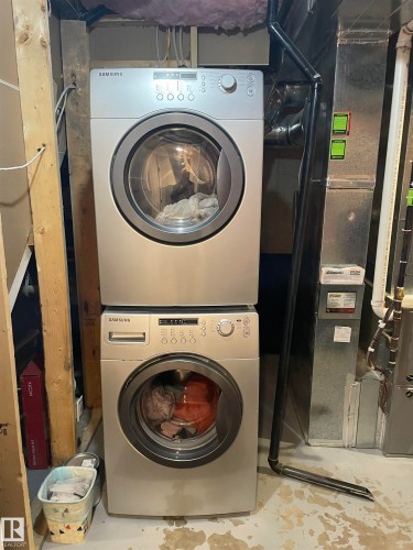 Laundry area featuring a stacked washer and dryer unit - 15220 105 Avenue, Edmonton, AB - Indoor Photo Showing Laundry Room