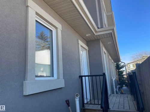 The property features a stucco exterior with decorative window trim and a light-colored soffit - 15220 105 Avenue, Edmonton, AB - Outdoor With Exterior