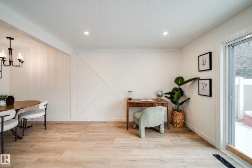 This open-concept area features a decorative accent wall, recessed lighting, and light-toned flooring - 125 Woodborough Way, Edmonton, AB - Indoor