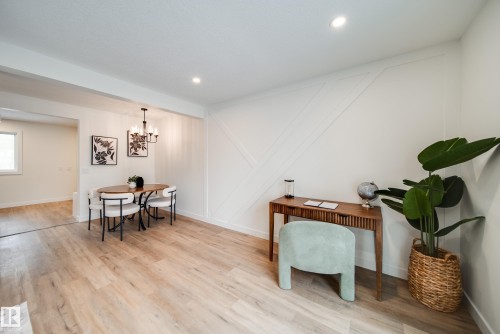 The property features light-toned flooring throughout, white walls with decorative paneling, and recessed lighting - 125 Woodborough Way, Edmonton, AB - Indoor