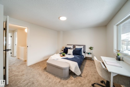 Well-appointed room featuring light-colored walls, textured carpeting, and a window providing natural light - 125 Woodborough Way, Edmonton, AB - Indoor Photo Showing Bedroom
