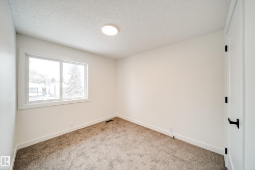 This room features a window providing natural light, white walls, and carpeted flooring - 125 Woodborough Way, Edmonton, AB - Indoor Photo Showing Other Room