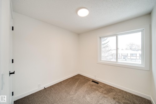 The room features light-colored walls, a window providing natural light, and a brown carpet - 125 Woodborough Way, Edmonton, AB - Indoor Photo Showing Other Room