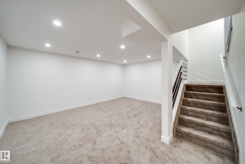 Spacious room featuring light-colored carpet, white walls, and recessed lighting - 125 Woodborough Way, Edmonton, AB - Indoor Photo Showing Other Room
