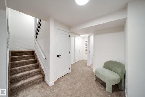 The property features a staircase with carpeted steps and a white handrail, leading to another level - 125 Woodborough Way, Edmonton, AB - Indoor Photo Showing Other Room