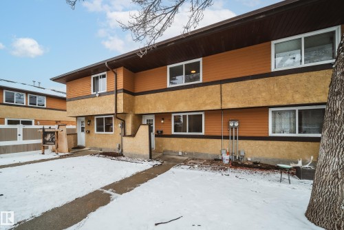 The property features a two-story exterior with brown siding and stucco accents, and white-framed windows - 125 Woodborough Way, Edmonton, AB - Outdoor With Exterior