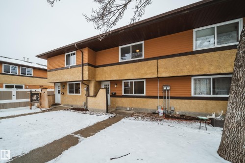 Exterior view of the property with a brown roof and orange siding, featuring a front yard with a concrete pathway - 125 Woodborough Way, Edmonton, AB - Outdoor With Exterior