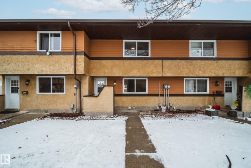 The property features a two-story exterior with a mix of textured stucco and horizontal siding, accented by white-framed windows and a dark brown roof - 125 Woodborough Way, Edmonton, AB - Outdoor
