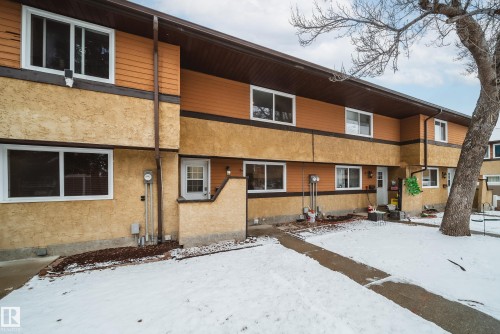 The property features a multi-story exterior with a combination of textured stucco and horizontal siding, complemented by white-framed windows - 125 Woodborough Way, Edmonton, AB - Outdoor