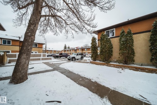 The property features a neutral-toned exterior with brown siding and a concrete pathway - 125 Woodborough Way, Edmonton, AB - Outdoor