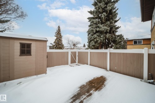 The property features a fenced yard, a storage shed, and mature evergreen trees - 125 Woodborough Way, Edmonton, AB - Outdoor