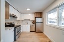 Modern kitchen featuring white and wood-grain cabinetry, stainless steel appliances, and light-toned flooring - 125 Woodborough Way, Edmonton, AB  - Indoor Photo Showing Kitchen 