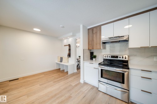 The property features a modern kitchen with stainless steel appliances, white cabinetry, and light-colored countertops - 125 Woodborough Way, Edmonton, AB - Indoor Photo Showing Kitchen