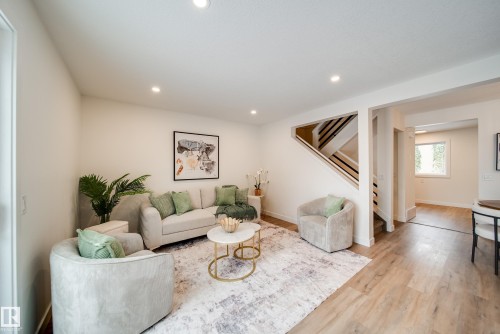 Inviting living area featuring light-toned flooring, recessed lighting, and a view of the stairway - 125 Woodborough Way, Edmonton, AB - Indoor Photo Showing Living Room